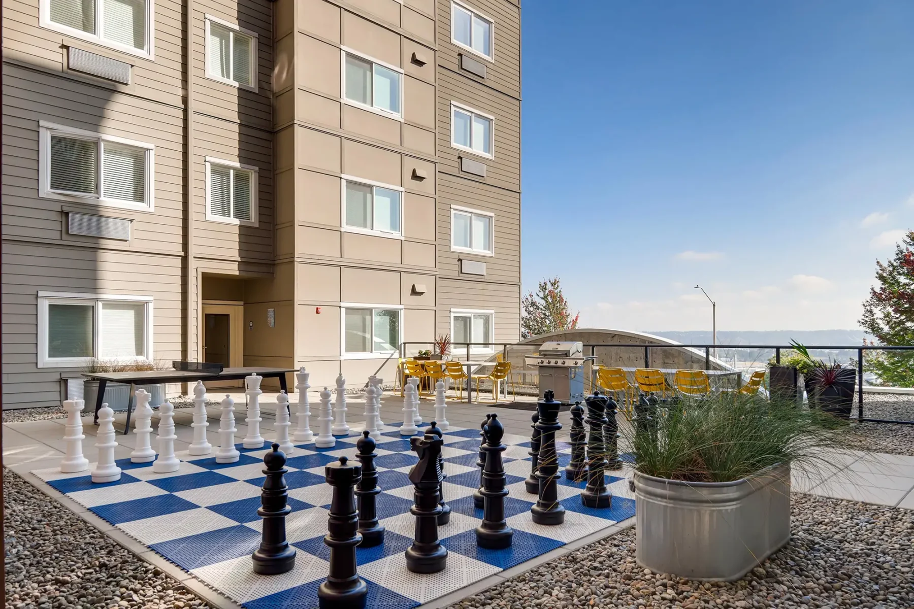 Outdoor courtyard with grill, ping pong table, and giant chess