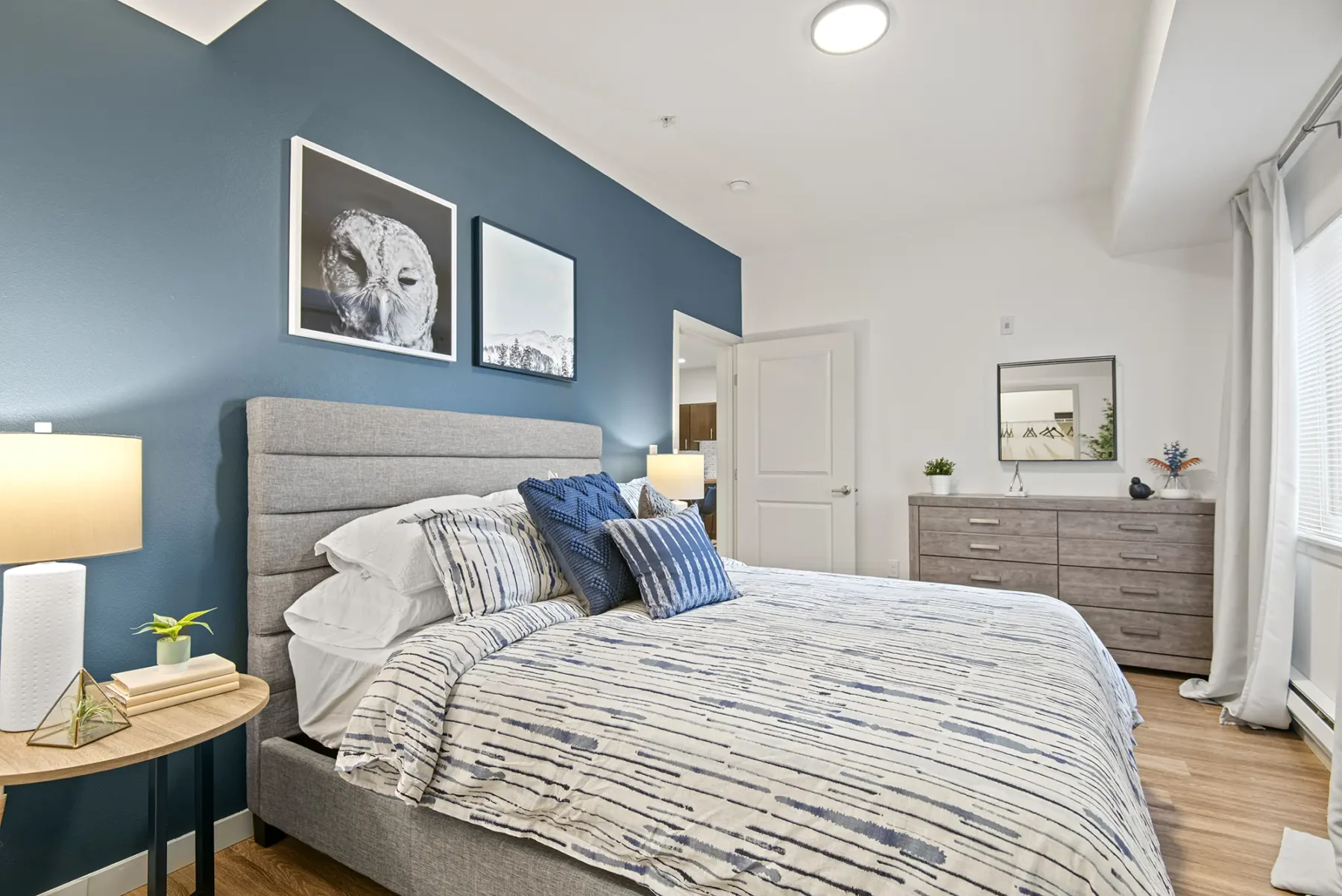 Bedroom with large windows and blue accent wall