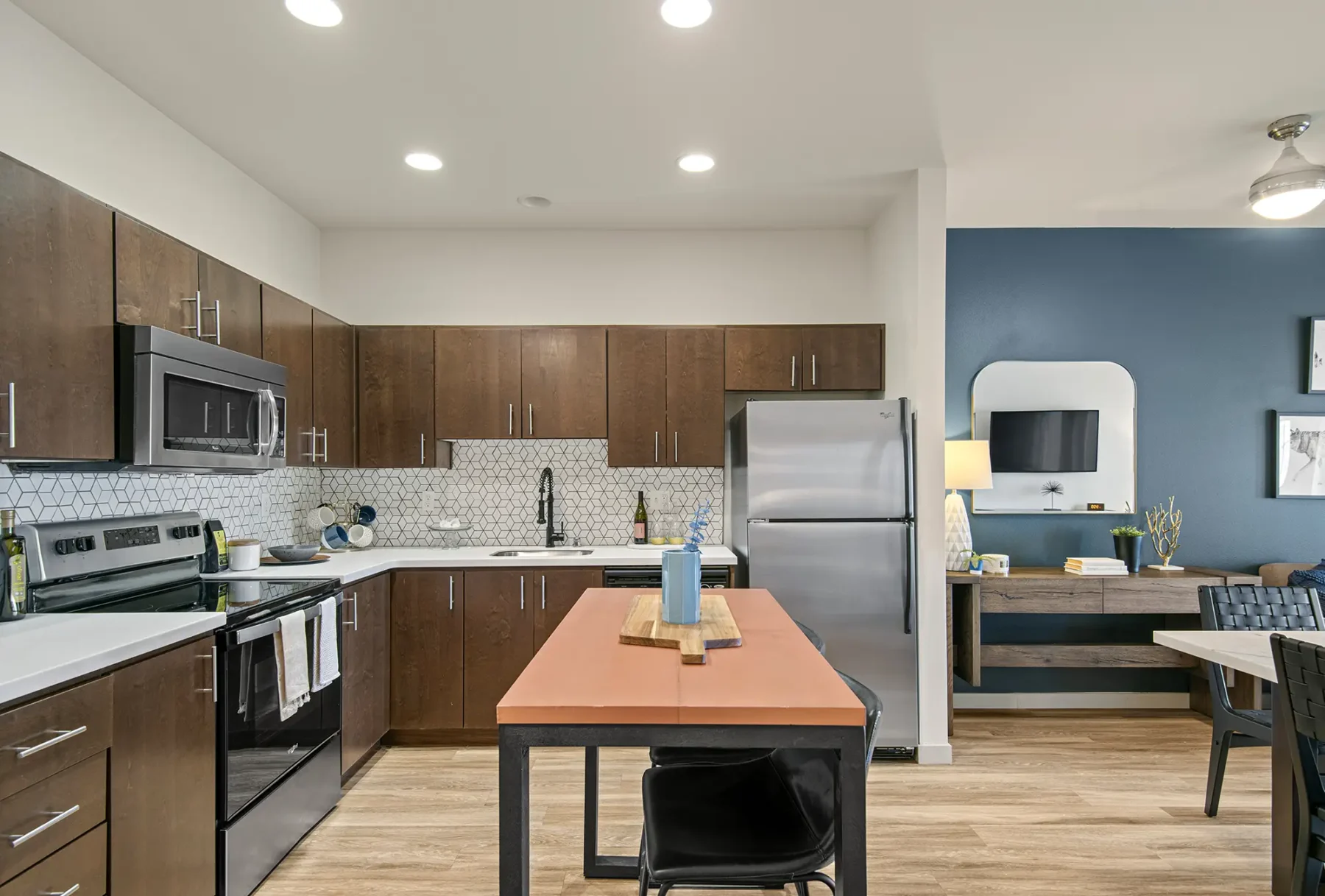 Kitchen with stainless steel appliances, tile back splash, and island seating