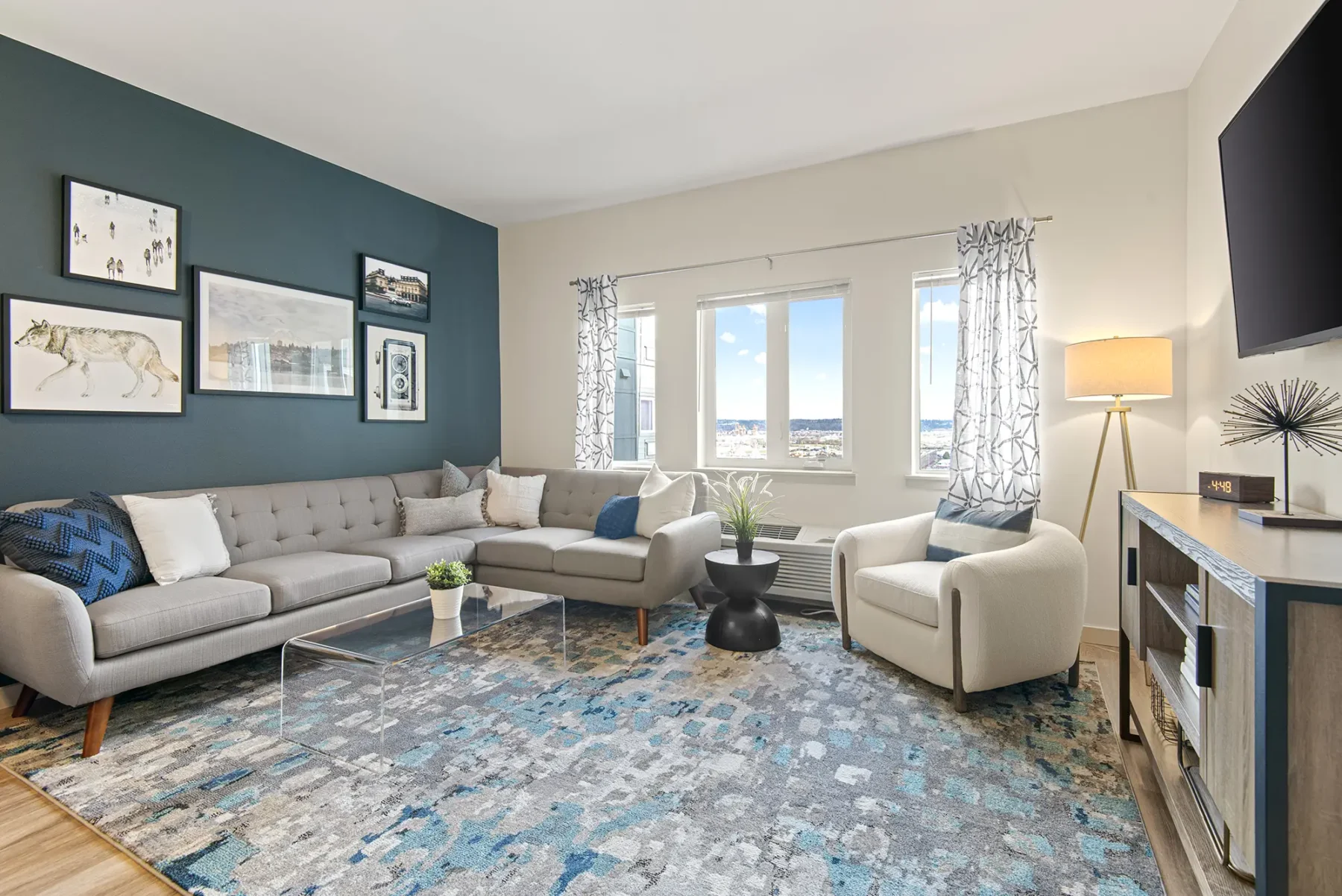 Staged living room with blue accent wall and large windows